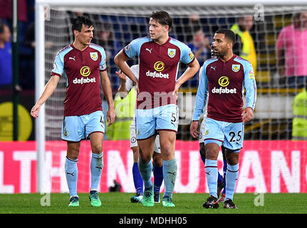 Burnley's Jack Cork (left), James Tarkowski and Aaron Lennon after Chelsea's Victor Moses (not pictured) scores his side's second goal of the game during the Premier League match at Turf Moor, Burnley. PRESS ASSOCIATION Photo. Picture date: Thursday April 19, 2018. See PA story SOCCER Burnley. Photo credit should read: Anthony Devlin/PA Wire. RESTRICTIONS: No use with unauthorised audio, video, data, fixture lists, club/league logos or 'live' services. Online in-match use limited to 75 images, no video emulation. No use in betting, games or single club/league/player publicat Stock Photo