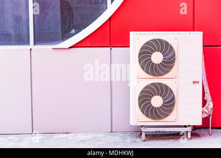 Air conditioner on wall of building outdoors Stock Photo