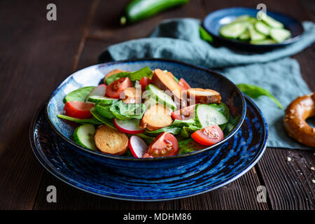 Brezensalat - traditional German salad with spinach, sliced tomatoes, radish, cucumber and pretzel croutons Stock Photo