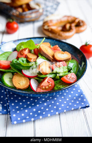 Brezensalat - traditional German salad with spinach, sliced tomatoes, radish, cucumber and pretzel croutons Stock Photo