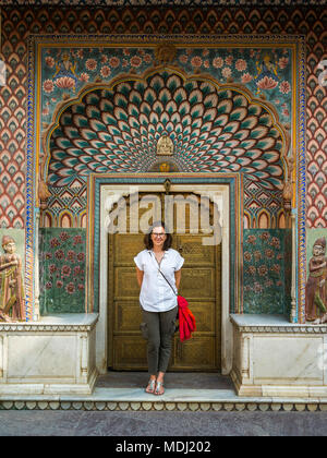 A female tourist stands in front of the Peacock Gate, City Palace; Jaipur, Rajasthan, India Stock Photo