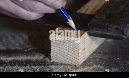 close up very close hands of a carpenter marking the cutting line with carpenter's ruler Stock Photo