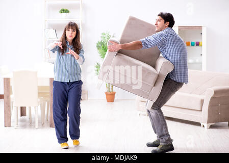 Man moving armchair in the living room Stock Photo