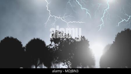 Lightning strikes in sky over trees silhouettes Stock Photo