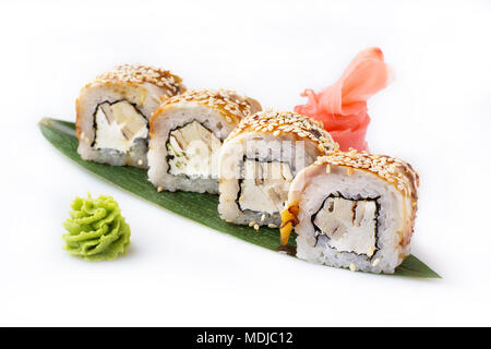 Exquisite and original rolls of sushi with eel, omelette and Philadelphia cheese laid out on a banana leaf. Isolated. Sushi roll on a white background Stock Photo
