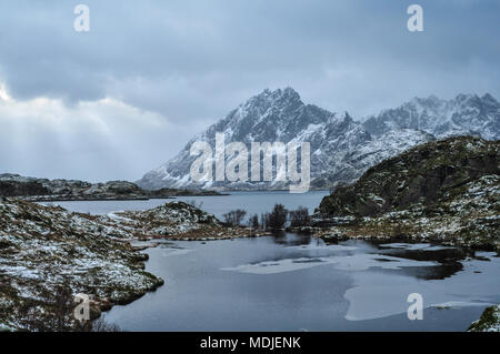 Frosty view on a norwegian fjord after snow showers with the sun breaking through the clouds Stock Photo