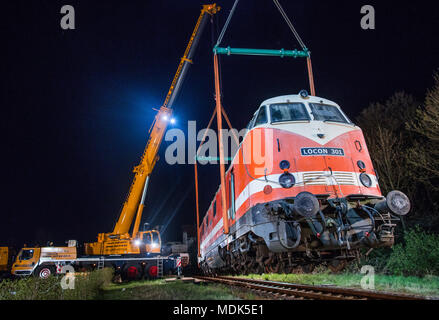 19 April 2018, Germany, Gadebusch: Two cranes lift a 78 tonne diesel locomotive of the model V-180 into the railway museum outside the local train station. The so-called 'cigar' locomotive was built in 1967. Photo: Jens Büttner/dpa-Zentralbild/dpa Stock Photo