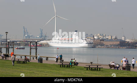 Gravesend, United Kingdom. 20th April, 2018. People relax at Gravesend Prom with cruise ship Astor pictured across the Thames at Tilbury. Gravesend in Kent is enjoying a baking hot day with high temperatures and bright sunshine. Gravesend often records the highest temperature of anywhere in the country. Rob Powell/Alamy Live News Stock Photo