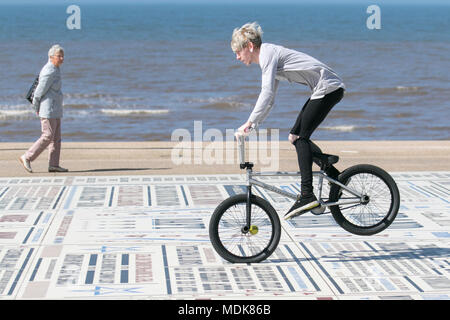 Young boy doing BMX stunts in Blackpool Lancashire. UK Weather. 20/04/2018.  Sunny start to the day on the Fylde Coast as holidaymakers enjoy he warm sunshine on the seafront promenade. Credit: MediaWorldImages/AlamyLiveNews Stock Photo