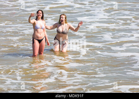 Bournemouth, Dorset, UK. 20th April 2018. UK weather: beaches are crowded as visitors flock to the beach to enjoy the hot sunny weather at Bournemouth. Two young woman having fun taking selfies in the sea. Credit: Carolyn Jenkins/Alamy Live News Stock Photo