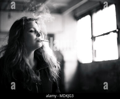 beautiful woman in ruined building smoking cigarette Stock Photo