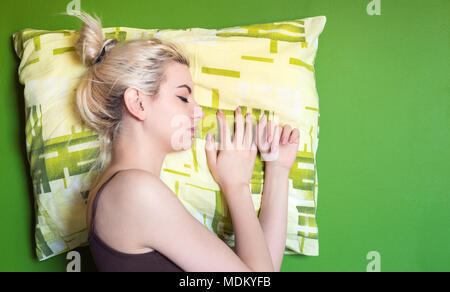 Young woman sleeping on green pillow and background Stock Photo
