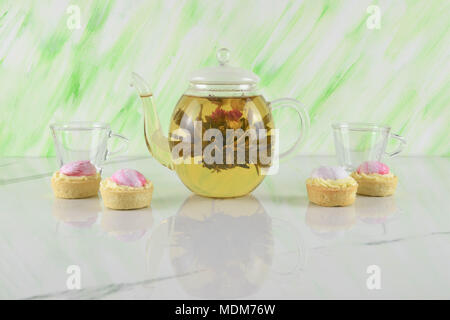 flowering tea in glass teapot with dessert Stock Photo