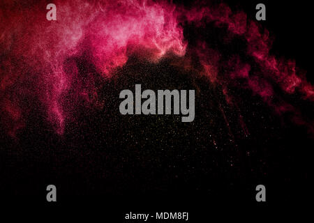 Red powder explosion on black background. Red dust splash on dark background. Stock Photo