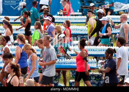 Volunteers hand out water bottles to exhausted runners in the aftermath of the Peachtree Road Race 10K on July 4, 2014 in Atlanta, GA. Stock Photo
