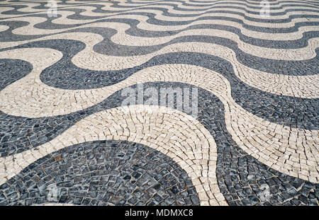 The wave shape pattern of tradition Portuguese pavement mosaic designed with black and white stones of basalt and limestone on the Rossio square. Lisb Stock Photo
