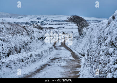Men an Tol stones in Penwith West Cornwall UK, 18/3/2018. The farm track leading back from the stones. Rare snow in Cornwall two weeks before Easter Stock Photo