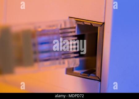 Macro close up of insert ethernet cable into WiFi extender device which is in electrical socket on the wall. The device is in access point mode that h Stock Photo