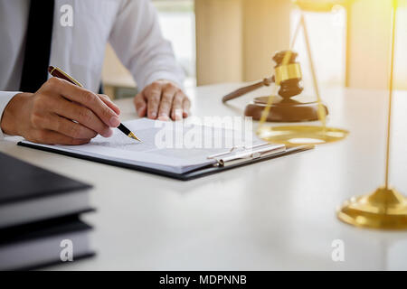 Justice and Law concept. Legal counsel presents to the client a signed contract with gavel and legal law or legal having team meeting at law firm Stock Photo