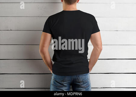 mockup of a black t shirt on a strong man holding your hands on your