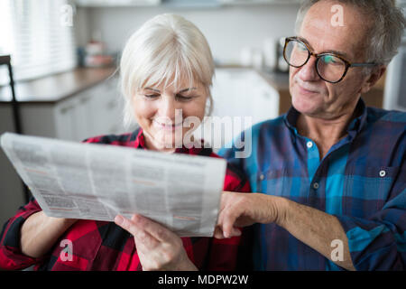 Portrait of senior couple reading newspaper together Stock Photo