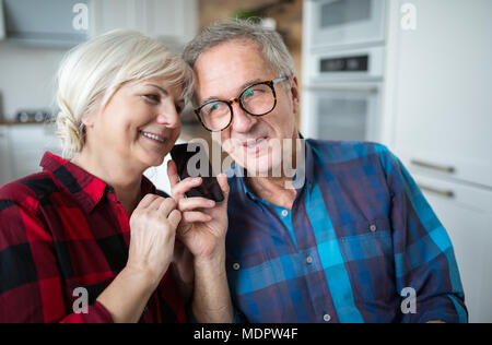 Portrait of happy senior couple having phone conversation Stock Photo