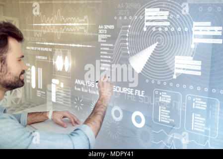 Young teacher making notes while using a new stylus Stock Photo