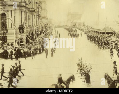 Black Watch regiment on parade. Location: Brisbane, Australia  Date:  1 January 1901  Description:  Scottish Black Watch troops are being led by a column of bagpipes players, on parade in Brisbane, in the year of Federation. The shot is taken from the corner of William and Queen streets as they turn right into Queen street past the Treasury building. Crowds line both sides of the street watching the troops pass by. Other spectators can be seen on the balconies of the Treasury building. Policemen wearing white helmets are positioned in front of the crowd with others on horseback in the immediat Stock Photo