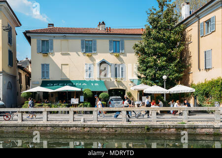 Milan, Italy - April 18th, 2018: People relax at a restaurant terrace in the popular Navigli district of Milan Stock Photo