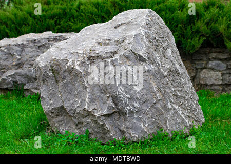 a bunch of ancient stone blocks lying on the grass. Stock Photo