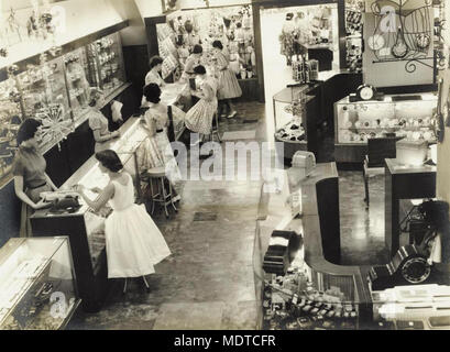 Section of the main showroom inside F W Nissen jewellery. Description: Section of the main showroom inside F. W. Nissen jewellery store in Brisbane, Queensland, ca. 1950. There are Christmas decorations hanging from the ceiling. Stock Photo