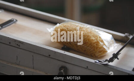 Food factory - conveyor with plastic pack of macaroni Stock Photo