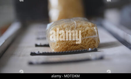Food industry - conveyor with plastic pack of macaroni Stock Photo