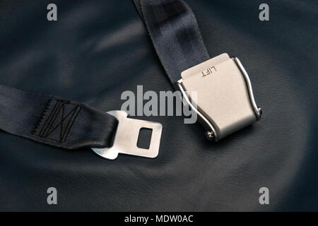 Seat belt on seat shot in airplane. Dark tone and Selective focus. unfastened seat belt. concept of the threat of airplane flight Stock Photo