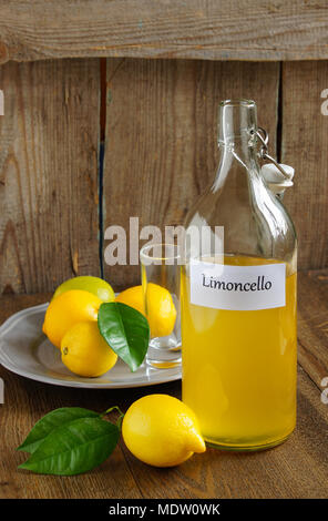 Italian alcoholic beverage, Limoncello on wooden table Stock Photo