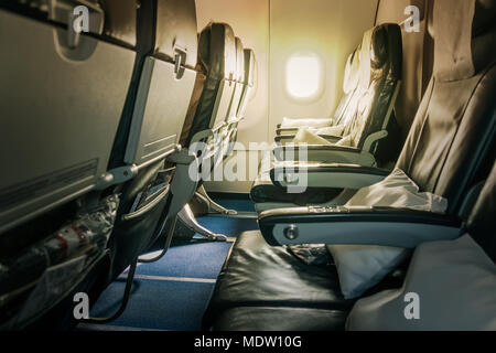 Airplane seat and window inside an aircraft. Inside the cabin of a Boeing. Seats in economy class. Stock Photo