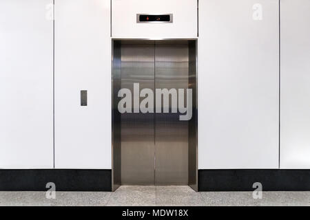 An empty modern elevator or lift with metal doors that are open in building with lighting. Stock Photo