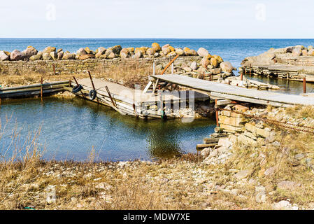 Old wooden walk bridge over an inlet in small coastal harbor. Location Aleklinta on Oland, Sweden. Stock Photo