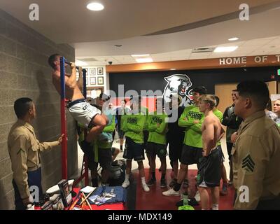 Wrestlers compete in a pull-up challenge at the Capital City Classic Wrestling tournament in Salt Lake City, Utah, Dec. 8, 2017. The Marine recruiters used the pull-up challenge  and table display to generate interest and spread knowledge about the Marine Corps,  as well as to interact with over 250 male and female wrestlers participating in the event. (U.S. Marine Corps photo by Sgt. Nicole Zurbrugg) Stock Photo