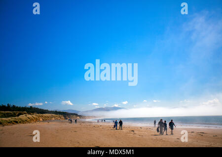 North Wales, UK 20th April 2018, UK Weather:  A high weather front will remain over the UK for the coming days and into the weekend people begin to head to the beach with visitors heading to Newborough Warren and beach on Anglesey in the warm weather and sea mist Â© DGDImages/Alamy Live News Stock Photo