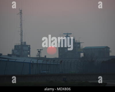 Sheerness, Kent, UK. 20th April, 2018. UK Weather: after a blistering hot day, the sea mist rolled in which with forecasted air pollution combined to give a muted sunset. The control tower and radar of Peel Ports London Medway and Medway VTS (Vessel Traffic Services). Credit: James Bell/Alamy Live News Stock Photo