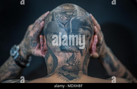 Frankfurt, Germany. 21st April, 2018.  A man presents his head tattoos at a tattoo convention where tattoo artists and enthusiasts travel from far and wide to exchange ideas, techniques and knowledge. Photo: Boris Roessler/dpa Credit: dpa picture alliance/Alamy Live News Stock Photo