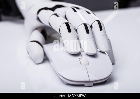 Close-up Of A Robotic Hand Using Computer Mouse Stock Photo