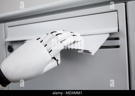 Close-up Of A Robotic Hand Inserting Envelope In Mailbox Stock Photo