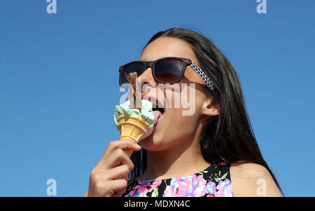 Isla Stanton enjoys an ice cream on the beach in Folkestone, Kent as the hot weather continues across the UK. Stock Photo