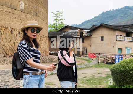 Tourist taking a selfie at Dadi Tulou; Fujian, China Stock Photo