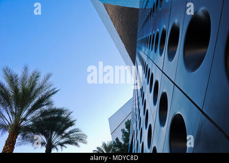 Unique facade of a building with circles in rows along the wall and blue sky with palm trees; Las Vegas, Nevada, United States of America Stock Photo