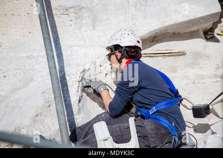 In February, 2015 detailed renovation work continued on the Trevi Fountain, in Rome. A woman wearing protective headgear on the side of the fountain. Stock Photo
