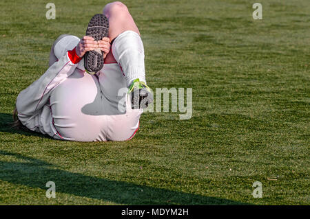 female football player lies injured on the ground Stock Photo