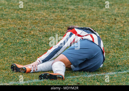 female football player lies injured on the ground Stock Photo